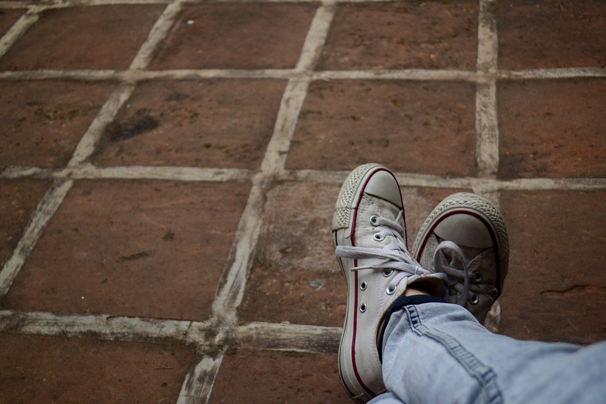 Typ Hosenboden Schreiberin Sneakers auf Gehwegplatten von Jules A, Unsplash